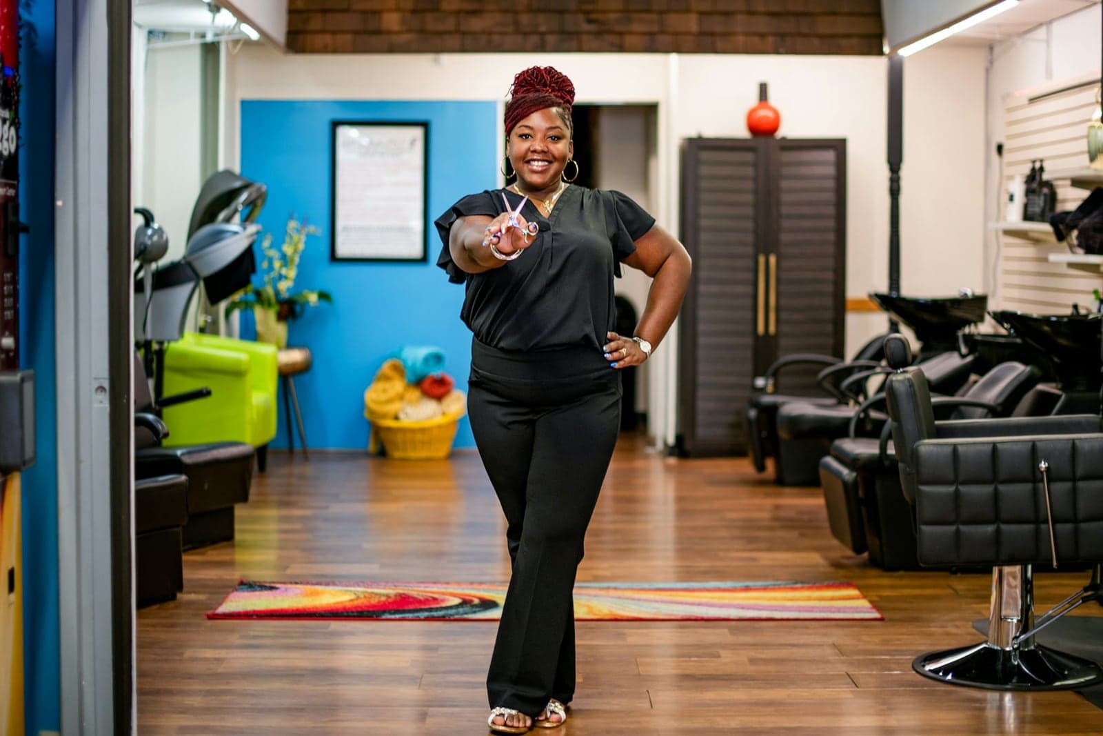 A salon owner standing in her business with tools in hand